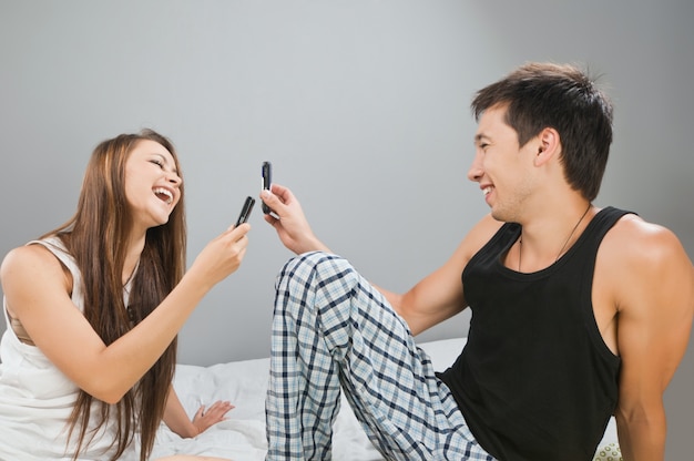 Foto grátis casal feliz com celulares