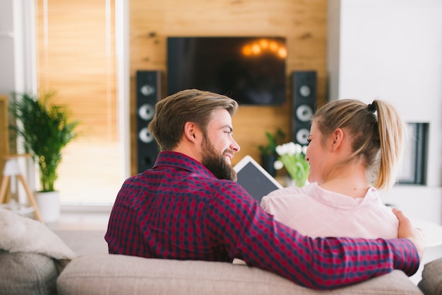 Casal feliz com tablet em casa