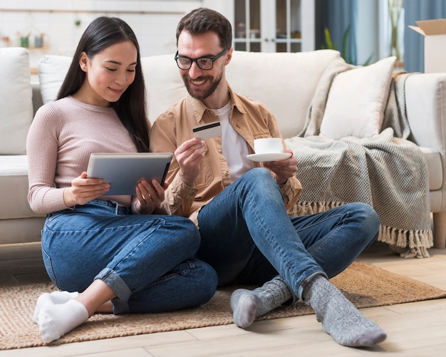 Casal feliz, compras on-line no tablet usando cartão de crédito