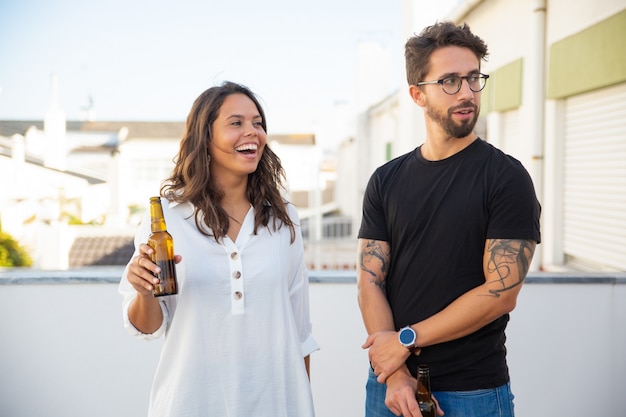 Casal feliz conversando, rindo, olhando para longe