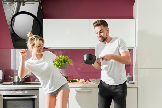 Casal feliz cozinhando dentro de casa