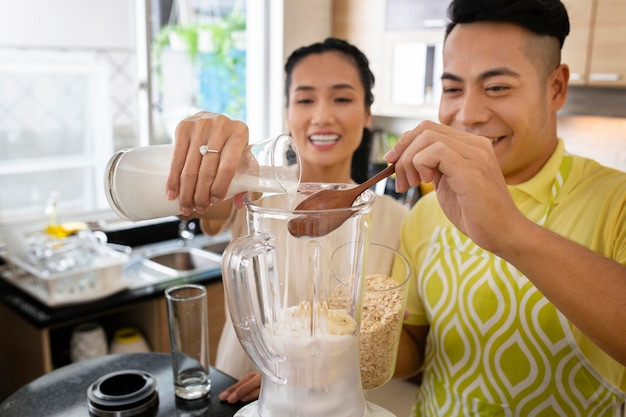 Casal feliz cozinhando em dose média