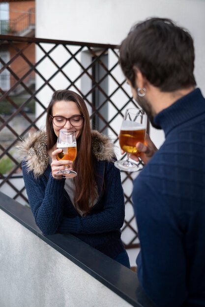 Casal feliz de tiro médio com bebidas em casa