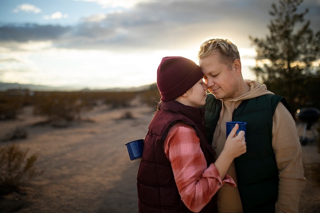 Foto grátis casal feliz de tiro médio com canecas