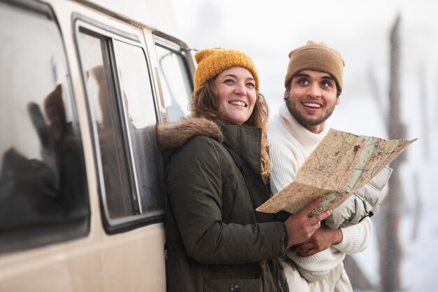 Casal feliz de tiro médio com mapa