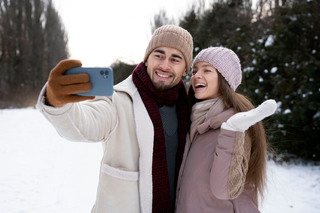 Casal feliz de tiro médio tomando selfie