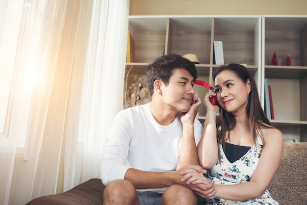 Casal feliz é relaxante e jogando juntos na sala de estar.