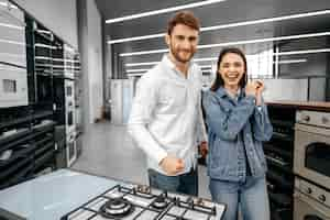 Foto grátis casal feliz e sorridente acaba de comprar novos eletrodomésticos em hipermercado