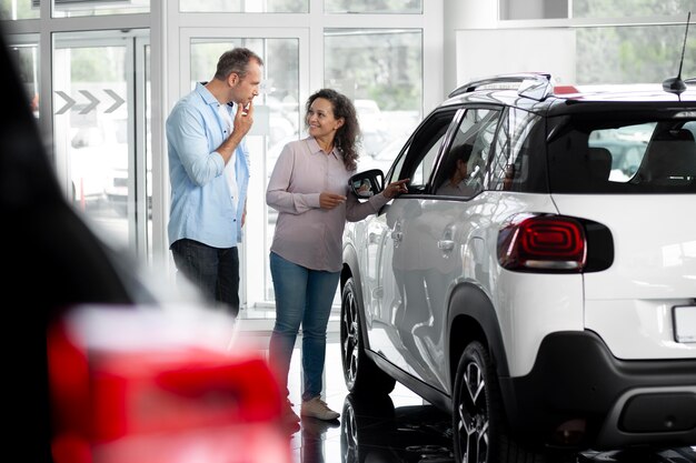 Casal feliz em concessionária de showroom de carros