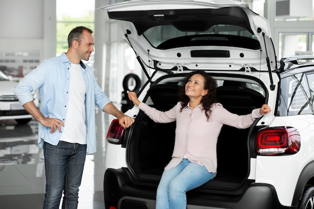 Casal feliz em concessionária de showroom de carros