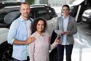 Foto grátis casal feliz em concessionária de showroom de carros