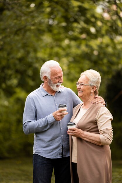 Casal feliz em dose média com xícaras de café