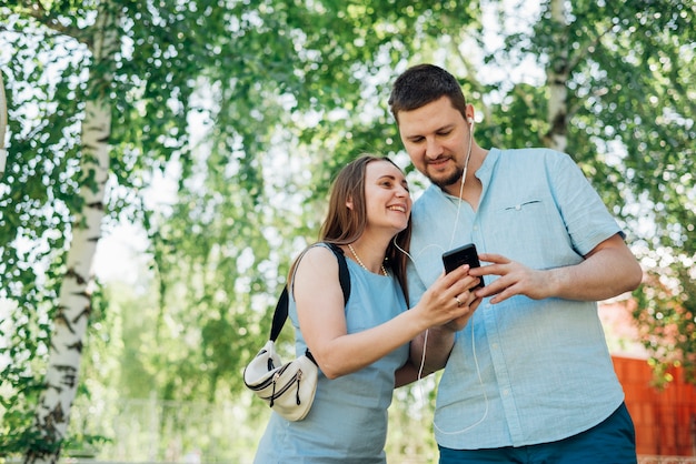 Casal feliz em fones de ouvido de mensagens no celular