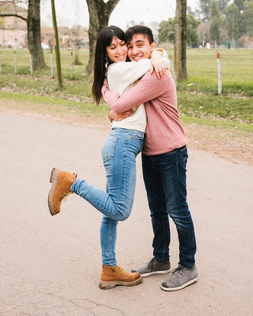 Foto grátis casal feliz em pé no asfalto e abraçando