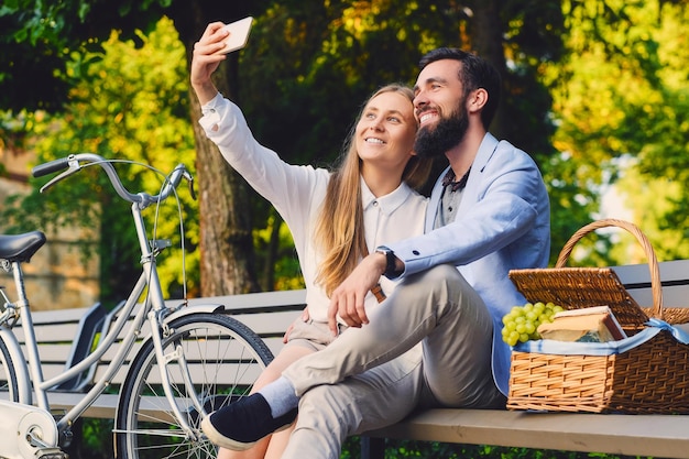 Casal feliz em um piquenique faz selfie.