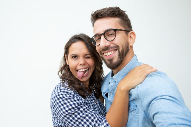 Casal feliz fazendo careta e olhando para a câmera