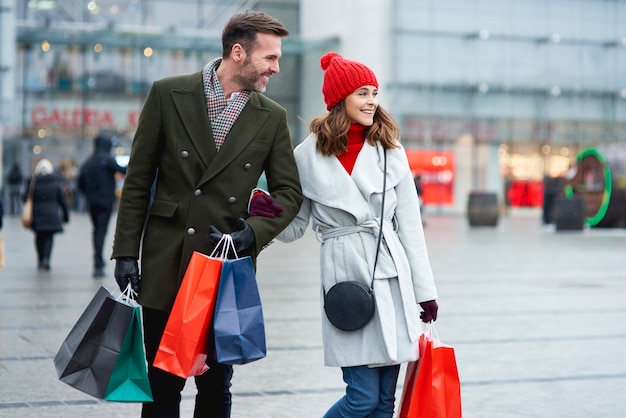 Casal feliz fazendo compras ao ar livre juntos