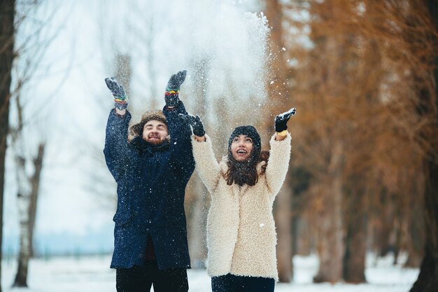 Casal feliz jogando neve