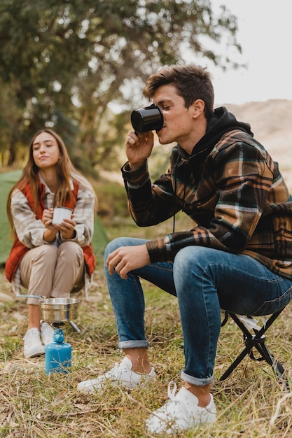 Casal feliz na floresta tomando café