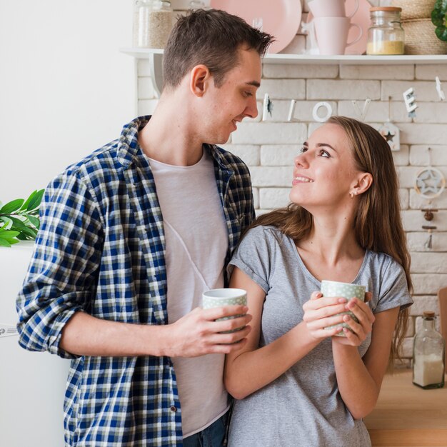 Casal feliz no amor juntos na cozinha olhando para o outro