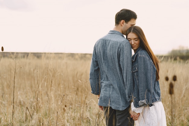 Casal feliz no amor no campo de trigo ao pôr do sol