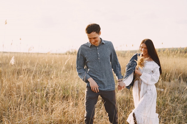 Casal feliz no amor no campo de trigo ao pôr do sol