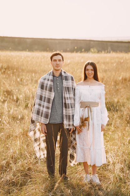 Casal feliz no amor no campo de trigo ao pôr do sol