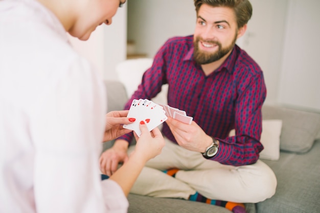 Casal feliz no jogo de cartas do sofá