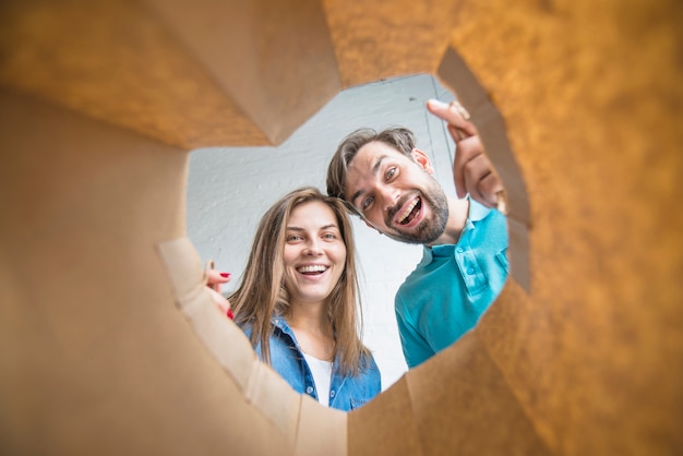 Foto grátis casal feliz olhando dentro do saco de papel