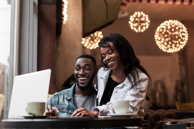 Casal feliz olhando para laptop