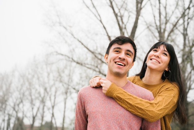 Casal feliz olhando para longe com alegria no parque