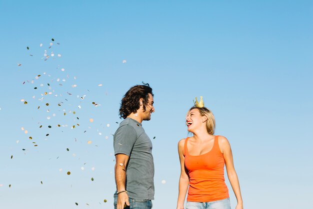 Casal feliz perto de confetes caídos