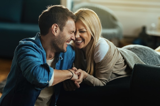 Casal feliz rindo enquanto fala sobre algo engraçado em casa