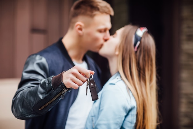 Foto grátis casal feliz se beijando e mostrando as chaves da nova casa