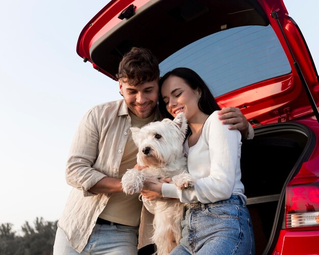 Casal feliz segurando um cachorro