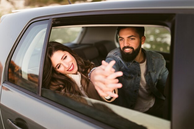 Casal feliz sentado nos bancos traseiros