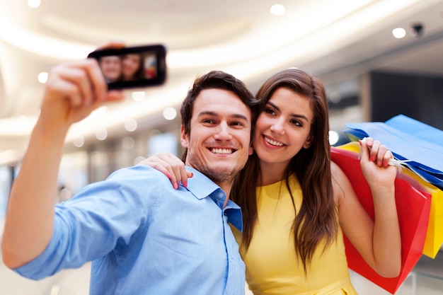 Casal feliz tirando uma foto durante uma compra