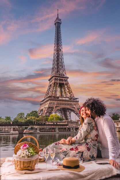 Casal feliz tomando vinho com vista para a Torre Eiffel