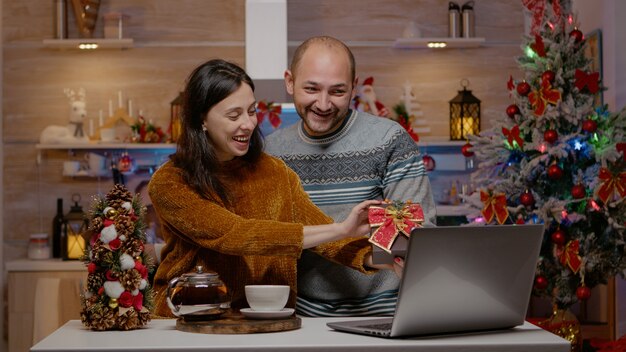 Casal festivo dando presentes em videoconferência