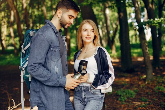 Casal fofo tem um descanso em uma floresta de verão