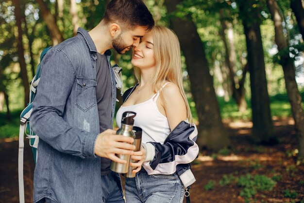 Casal fofo tem um descanso em uma floresta de verão