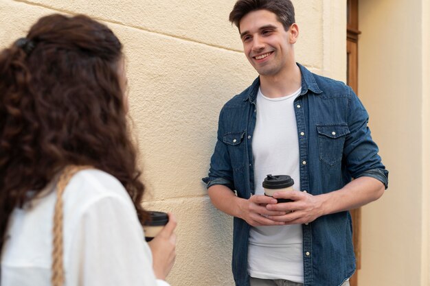 Casal fofo tomando uma xícara de café ao ar livre