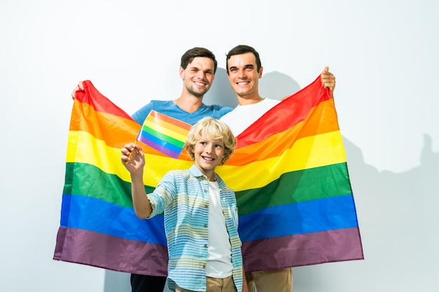 Casal gay da família lgbt com filho adotivo pais homossexuais com filho se divertindo em casa Foto Premium