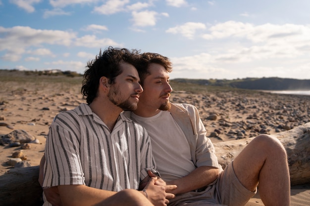 Foto grátis casal gay de tiro médio na praia