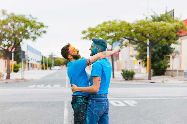 Casal gay feliz abraçando na estrada