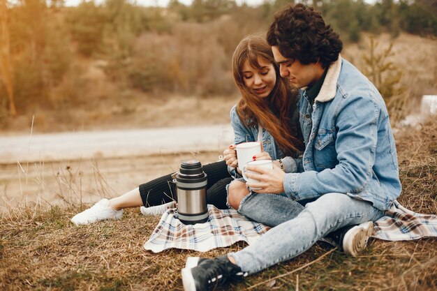 casal gentil e elegante, sentado no parque outono e beber um chá