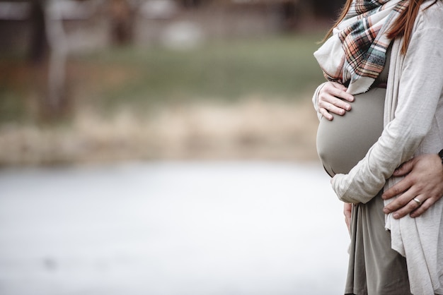 Foto grátis casal grávida com as mãos na barriga