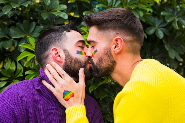 Casal homossexual beijando no jardim