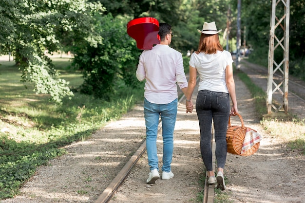 Casal indo embora ao longo dos trilhos do trem