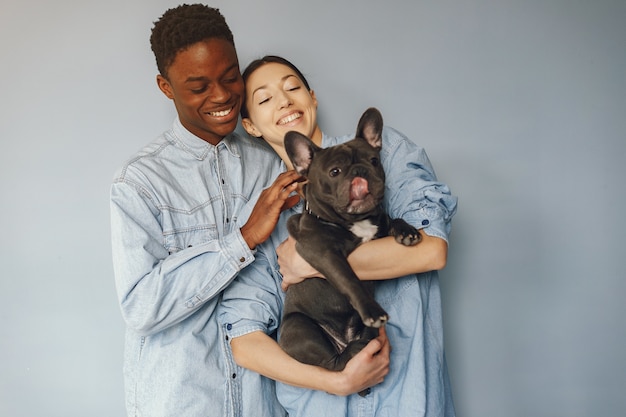 Casal internacional em um fundo azul com um cachorro